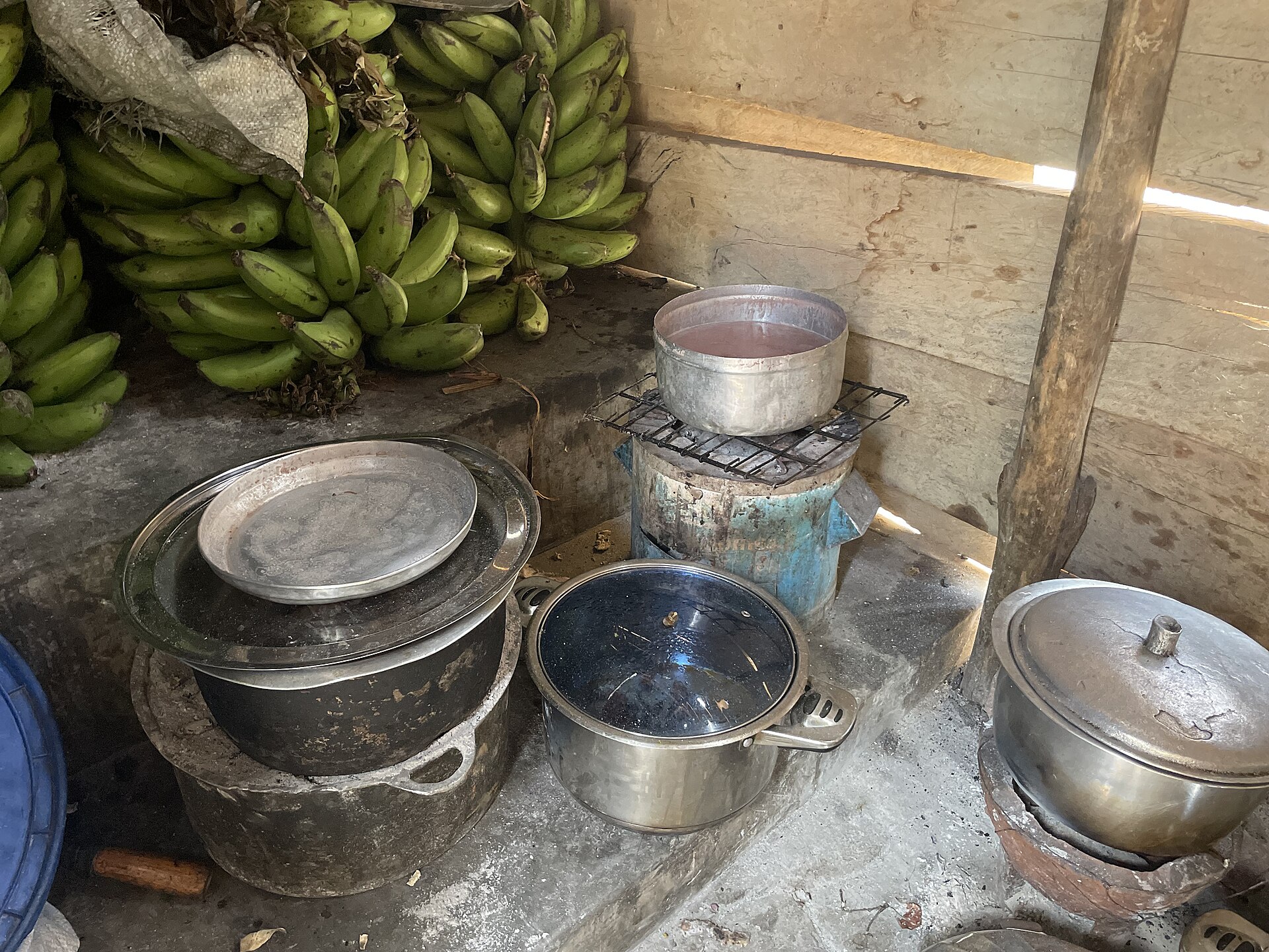 Pans and charcoal stoves in a cooking area in 2025.