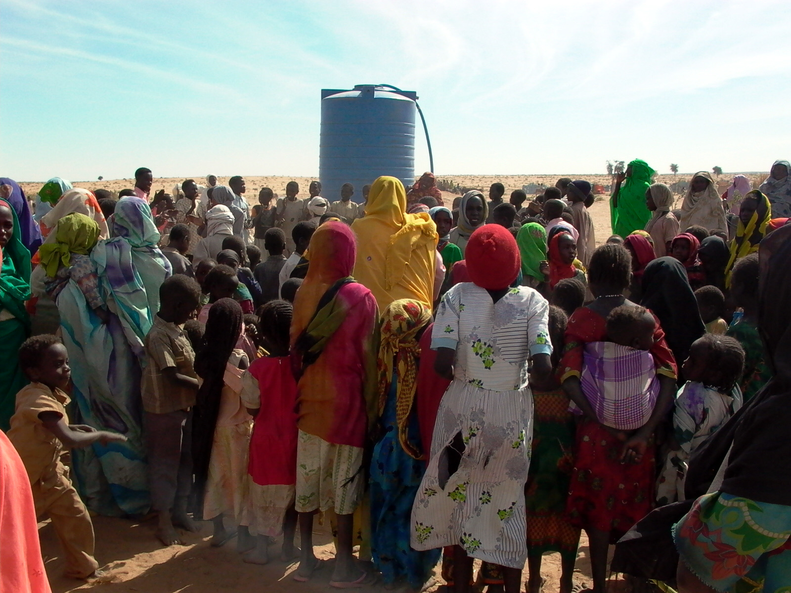 Displaced people gather at a water tank in West Darfur in 2007, during an earlier phase of the conflict.